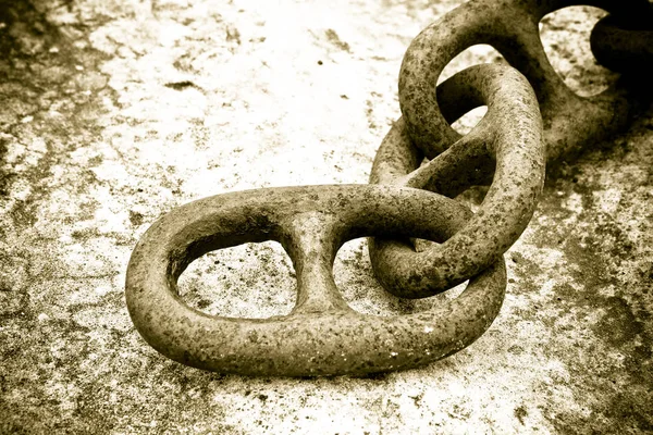 Detail of an old rusty metal chain anchored to a concrete block — Stock Photo, Image