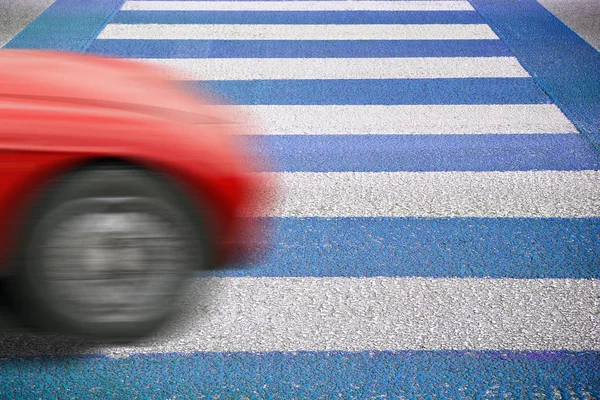 Blauwe en witte voetgangersoversteekplaats met auto op voorgrond — Stockfoto