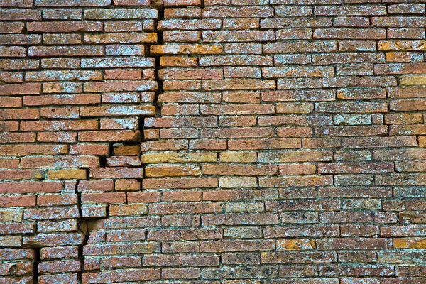 Cracked brick wall. Deep crack in a brick wall