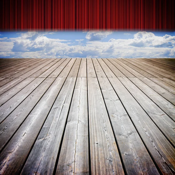 Öppna Teaterns röda gardiner och trägolv mot en molnig himmel — Stockfoto