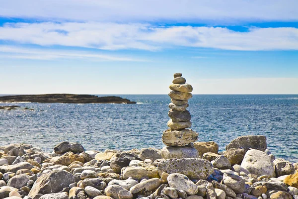 Mare calmo con pietre zen contro un paesaggio naturale - immagine arguzia — Foto Stock