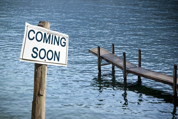 Wooden pier by the lake with coming soon signboard - concept ima — 스톡 사진