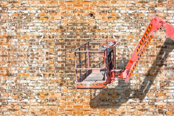 Aerial platform for repairing works against a brick wall - image — Stock Photo, Image
