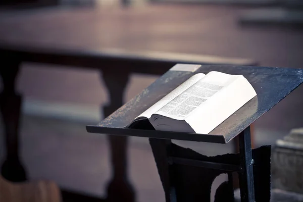 Öppen bok ovanför en talarstol i kyrkan — Stockfoto