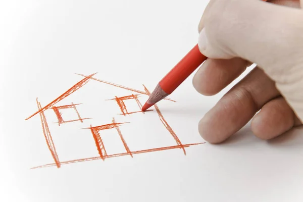 Hand ritning ett hus med en penna på vitt ark — Stockfoto