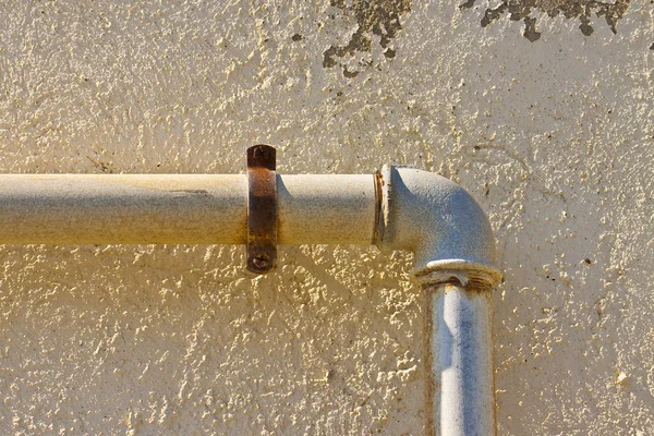 Old water and gas pipes varnished in yellow and fixed with metal — Stock Photo, Image