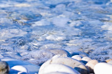 Taze şeffaf su altında yuvarlak beyaz taşlar