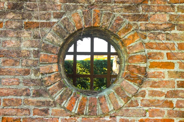 Staré kolo okno na cihlové zdi — Stock fotografie