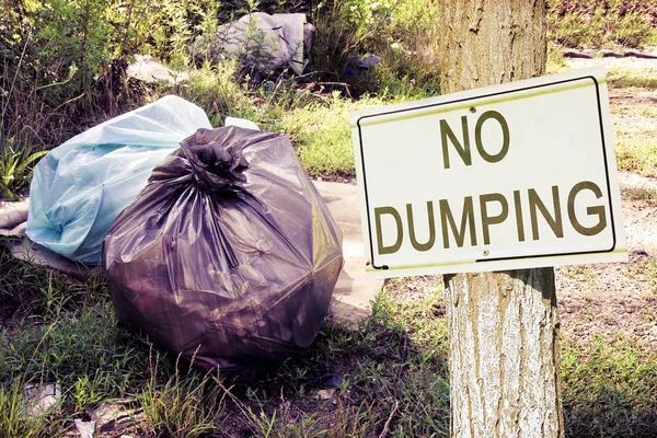 Dumping ilegal na natureza com o sinal "Sem Dumping" indicando — Fotografia de Stock