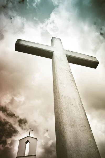 Croix chrétienne en béton contre un ciel nuageux dramatique - concept — Photo