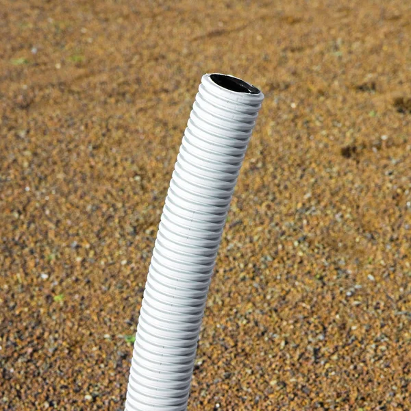 Corrugated pipe with cable coming out from the ground