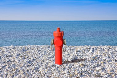 An improbable hydrant at the seaside. Plenty of water concept im clipart
