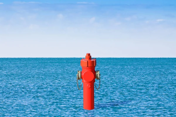 Un hidrante improbable en la orilla del mar. Un montón de concepto de agua im —  Fotos de Stock