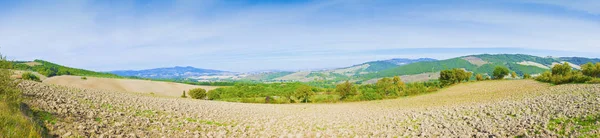 Toskanische Landschaft mit gepflügten Feldern im Vordergrund - Panorama — Stockfoto
