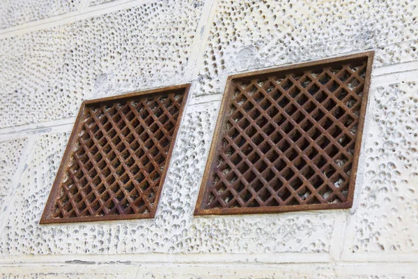 Cast iron ventilation grilles against a plaster wall — Stock Image Cast iron ventilation grilles against a plaster wall Royalty Free Stock Images