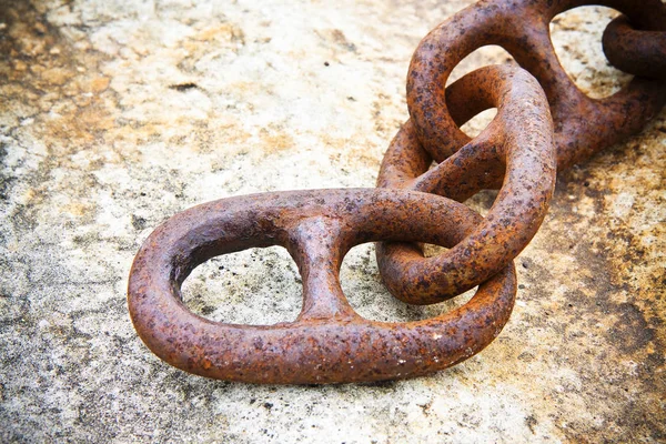 Detail of an old rusty metal chain anchored to a concrete block — Stock Photo, Image