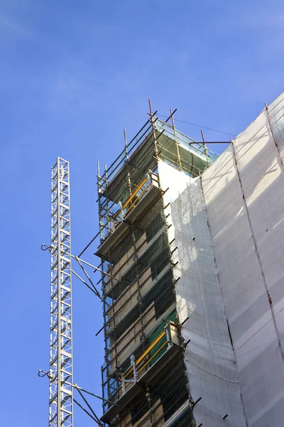 Lešení pro práci na fasádě na modrém pozadí — Stock fotografie