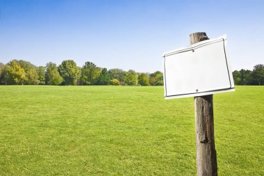 Ahşap boş işareti ile yeşil mowed çim karşı gösteren Tre