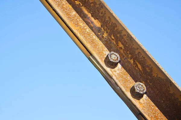 Old rusty iron structure with bolted metal profiles against a bl — Stock Photo, Image