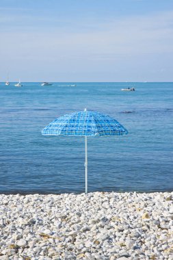 Küçük taşlar kumsalda izole renkli şemsiye