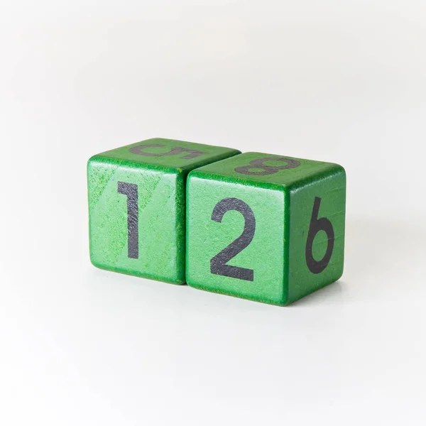 Nummer twaalf geschreven op een houten groene kubus op witte achtergrond — Stockfoto