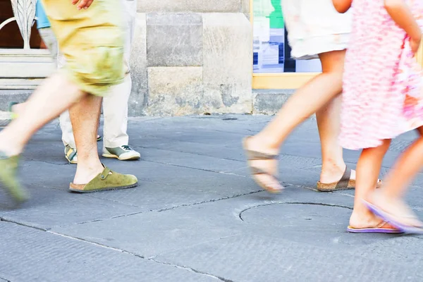 Pedestrians in a Italian city walking in a stone street