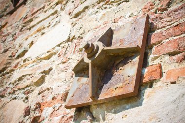 Metal plakalarla güçlendirilmiş eski tuğla duvar