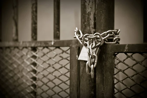 Gerbang logam ditutup dengan gembok sepia toned — Stok Foto
