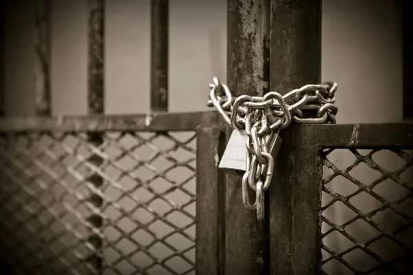 Puerta metálica cerrada con candado - sepia tonificada — Foto de Stock