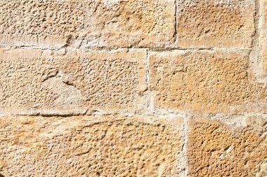 Eski ortaçağ İtalyan taş duvarı, parçalanmış bloklarla inşa edilmiş, yakın zamanda restore edilmiş.  