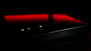 Kırmızı arka planda yanıp sönen LED ışıkları olan WI-FI yönlendiricisi çalışıyor