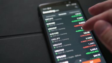 Adam akıllı telefondan borsa fiyatlarını izliyor.