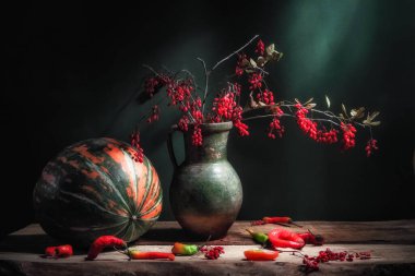 Klasik hayat, büyük çizgili pampkin, güzel Berberis böğürtlen dalıyla antika bir sürahi kırmızı böğürtlen ve ahşap masa ve yeşil arka planda sıcak kırmızı paprkia. Sanat fotoğrafçılığı.