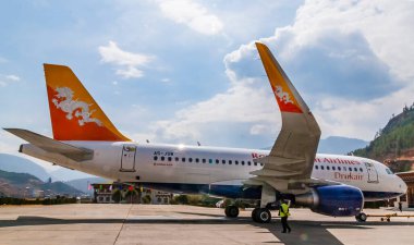Paro / Butan - 26 Şubat 2016: Drukair - Paro Havaalanı 'nda Royal Butan Airplane Airbus A319. Himalaya dağları arka planda.
