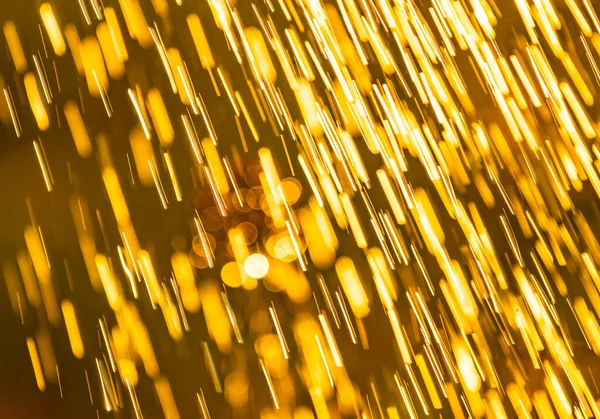 Abstract background of heavy rain shower with waterdrops in the golden rays of the sun in summer. Fresh rainy summer background. Rain and sun.