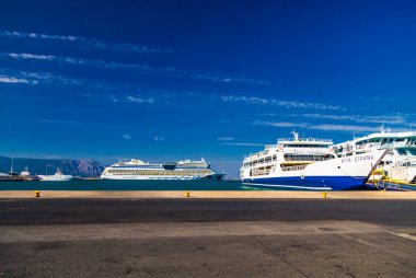 Kerkira, Corfu, Yunanistan: 24 Eylül 2018 - feribot Agia Eirini veya Saint Irene ve Alman yolcu gemisi Aidablu Yunanistan 'ın Korfu adasının başkenti Kerkira' nın deniz limanında. Büyük gemilerin arka planındaki küçük araba..