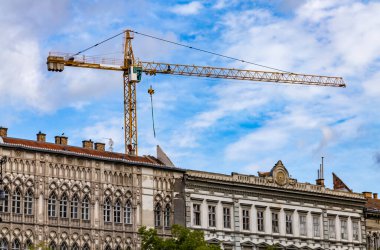 Budapeşte 'deki eski barok binasının arka planında büyük bir vinç var..