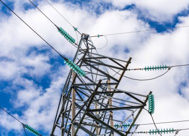 Şeffaf bir turkuaz yüksek voltaj yalıtıcısını kapat ya da mavi gökyüzü arka planındaki elektrik kulesinde güneş ışığında izolatör..