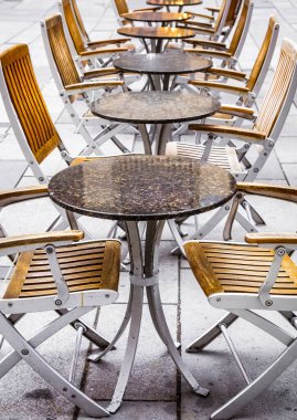 Coronavirus COVID-19 çarpışma karantinası yüzünden caddedeki kafede kimse yok. İnsan yok. Boş restoran ve kafeterya masaları.