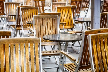 Coronavirus COVID-19 çarpışma karantinası yüzünden caddedeki kafede kimse yok. İnsan yok. Boş restoran ve kafeterya masaları.