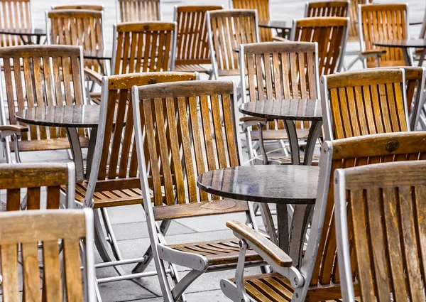 Coronavirus COVID-19 çarpışma karantinası yüzünden caddedeki kafede kimse yok. İnsan yok. Boş restoran ve kafeterya masaları.