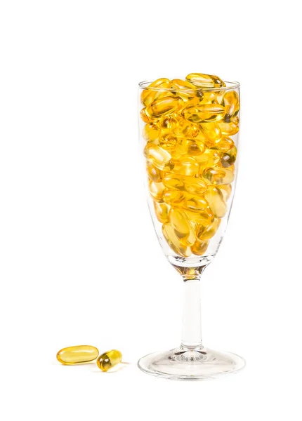 含鱼油的透明酒杯橙黄色软糖胶囊包裹鱼油欧米加3或欧米加6 欧米加9 维生素A 维生素D 维生素E 分离于白底 健康饮食概念 — 图库照片