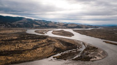 Güzel nehir ve Sibirya 'nın tepelik arazisindeki uzun yol. Ulan-Ude şehri. Gri gökyüzü. Hava görüntüsü