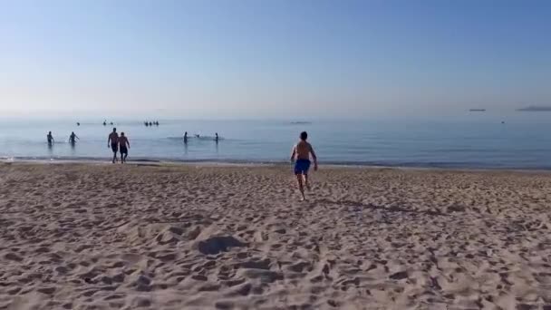 Jongeman duikt in de Zwarte Zee in Odessa. De mens verheugt zich erover dat de quarantaine in verband met de COVID-19 pandemie is voltooid en dat de stranden open zijn. Luchtzicht — Stockvideo