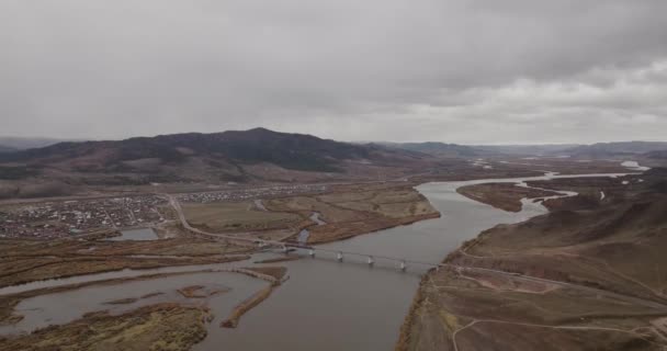 Widok z lotu ptaka na rzekę, długi most i wzgórza na Syberii w pobliżu miasta Ulan-Ude. FOOTAGE 4K — Wideo stockowe
