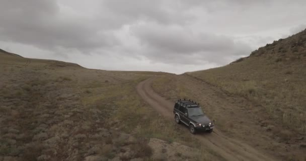 Luchtfoto van een oude jeep rijdt op hoge heuvels rond de stad Ulan-Ude, Siberië, Rusland. 4K — Stockvideo