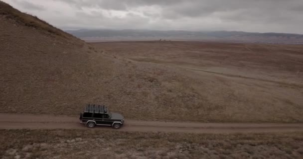 Vue aérienne d'un véhicule tout terrain circulant sur de hautes collines autour de la ville d'Ulan-Ude, en Sibérie, en Russie. DJI Mavic Pro 4K. 4x4 — Video