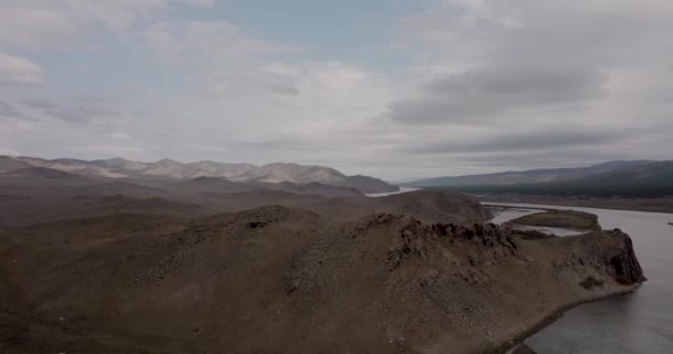 Dramática caída oscura estepa del desierto en una meseta montañosa con rangos de colinas en un horizonte horizonte de tormenta. Vista aérea del río y colinas en Siberia cerca de la ciudad de Ulan-Ude, Rusia. 4K — Vídeo de stock