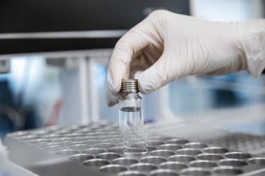 Polimeraz zinciri reaksiyonu için bir test tüpünü DNA örnekleriyle doldururken yakın çekim. Mavi tonda resim