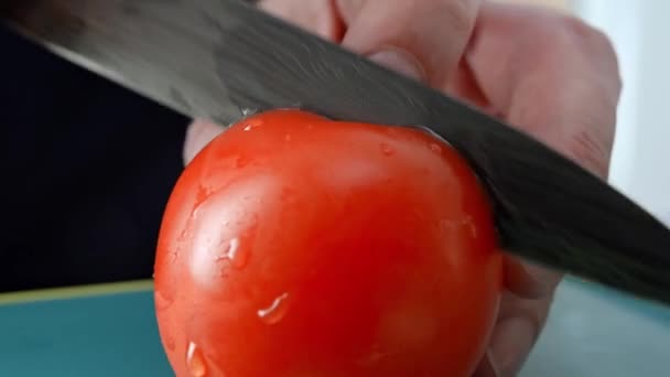 Cortar tomate rojo en la luz de fondo de la mañana. Cortar las verduras frescas para cocinar en la luz de la mañana. Macro. Corte de tomate de cerca. Luz natural del sol. Alimentación saludable. Procesamiento de alimentos. Full HD — Vídeos de Stock